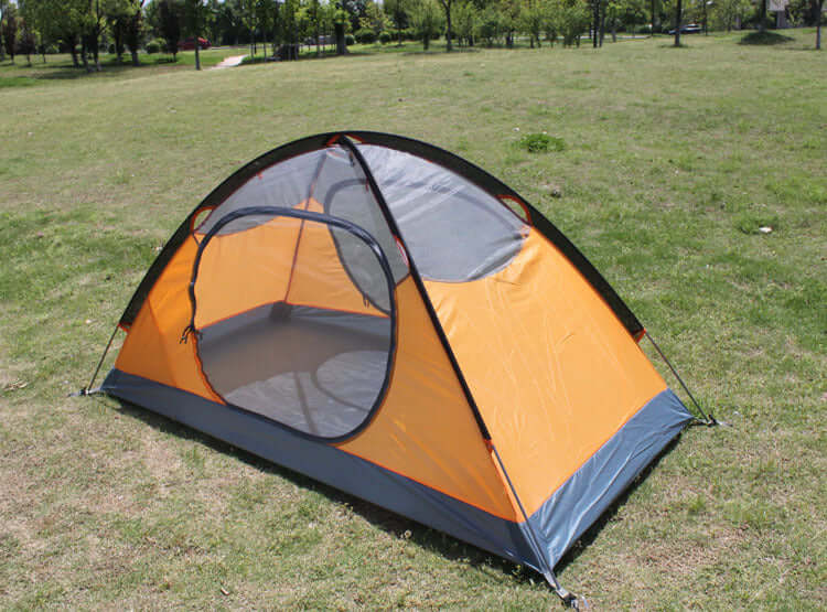 Outdoor double camping tent with rainproof features, set up on a grassy area, ideal for high mountain camping.