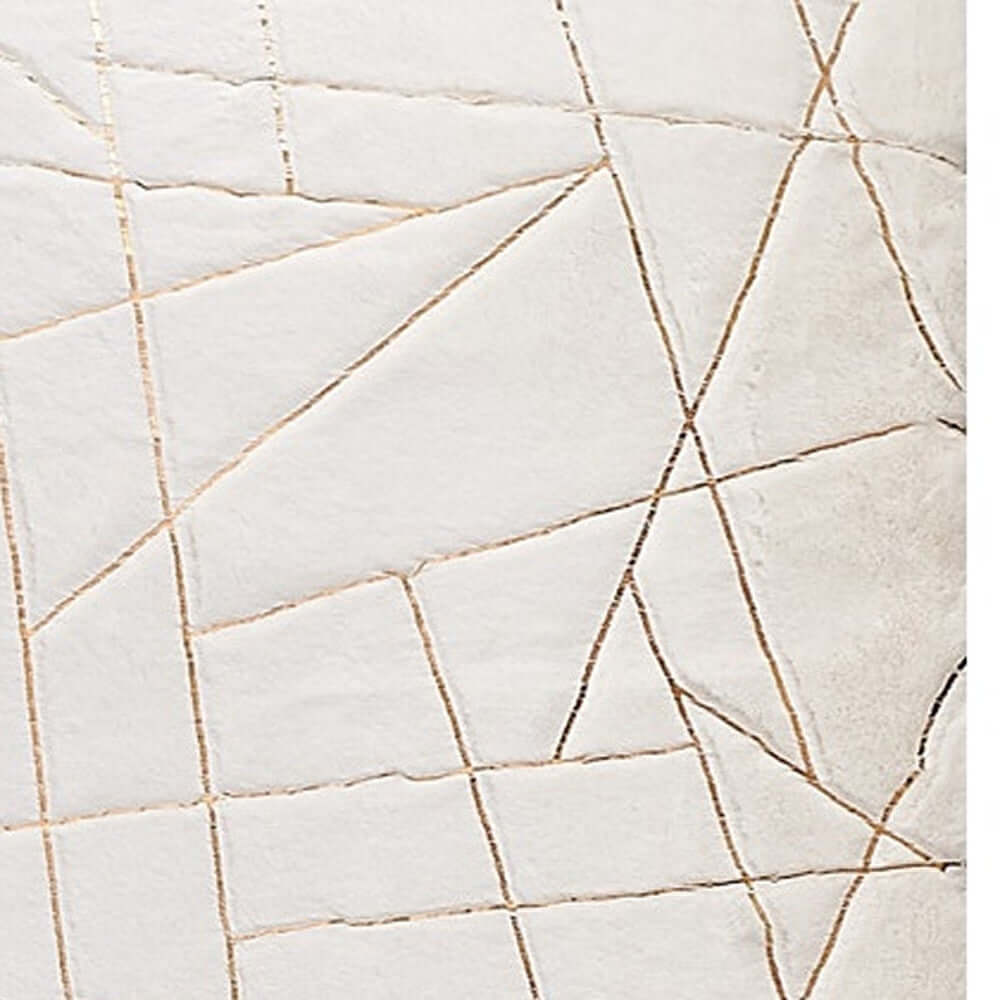 Close-up of white and gold abstract pattern on a faux fur area rug, showcasing a chic, modern design.