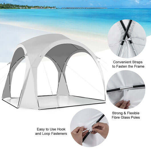 Portable white patio sun shade tent setup with fibreglass poles, convenient straps, and hook fasteners on a beach.